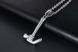 Macro shot of silver hammer pendant on black leather with a polished industrial finish