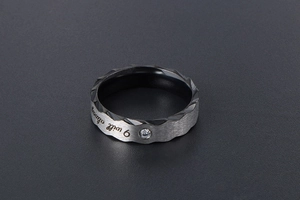 Detail of two-tone titanium ring with brushed silver finish and 'I will always' engraving