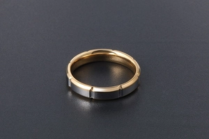 Détail de bague en acier titane bicolore avec bords dorés et finition mate argentée