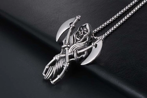 Macro shot of silver stainless steel grim reaper pendant with scythes and box chain