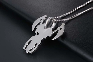 Close-up of silver steel double-edged axe pendant with cutout design on bead chain