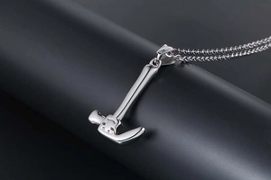 Close-up of polished stainless steel mini hammer pendant with textured grooves on chain