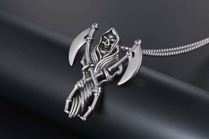 Detailed macro view of gothic reaper pendant with crossed scythes in polished steel