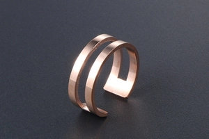 Close-up of double-layered rose gold ring showing brushed metal texture and open band