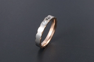 Macro shot of wave-edge titanium steel ring with zircon inlay and unique letter engraving