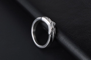 Detailed close-up of a silver pentagram stainless steel ring on black leather surface