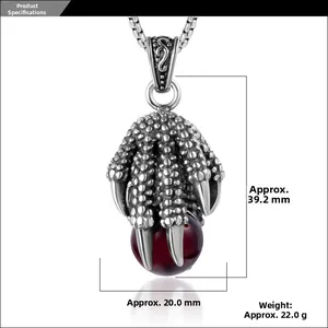 Macro detail of retro dragon claw pendant with red stone on stainless steel chain