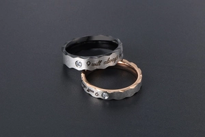 Detail of engraved couple rings with wave-cut edges and small zircon stone inlay