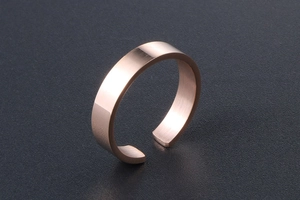 Detail of a minimalist rose gold open ring with polished and brushed metal textures