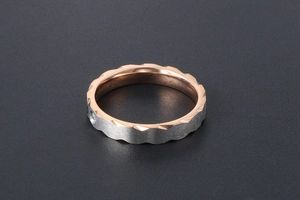 Detail of two-tone titanium ring with frosted silver surface and rose gold jagged edges