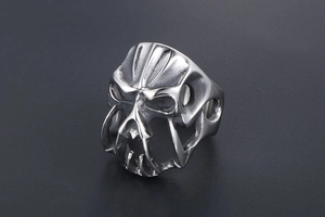 Macro shot of silver punk skull ring with gothic tribal carvings and dark oxidized finish