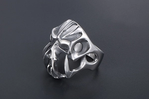 Macro shot of gothic monster face sculpture on stainless steel ring with polished finish