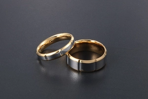 Détail de bagues de couple en titane bicolore avec surface grise brossée et bande dorée