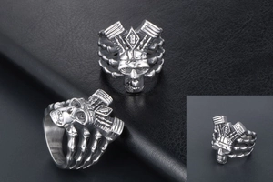 Macro detail of men's punk skull ring featuring engine parts and engraved 'B' logo