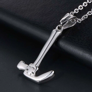 Polished silver hammer pendant necklace with sleek metal chain on black leather background