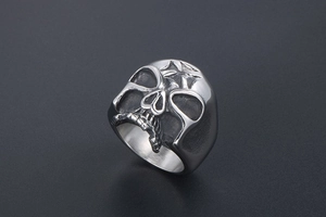 Detail of vintage silver skull ring with star engraving and gothic distressed finish