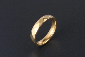 Vista macro dell'anello in oro 18K con sfaccettature geometriche su superficie nera