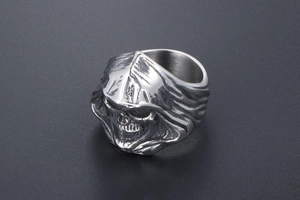 Macro detail of gothic skull ring with hooded reaper design and polished silver finish