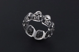 Close-up detail of vintage silver skull ring with gothic punk rock engraving textures