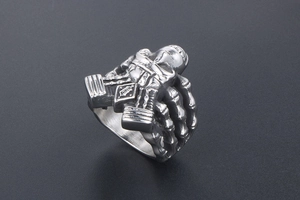 Close-up of gothic skull ring with mechanical details and a B-letter crest emblem