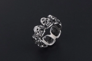 Detailed close-up of a vintage skull ring featuring intricate punk rock carvings