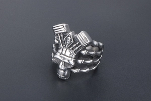 Detail of punk skull ring with V-twin engine design and B-letter engraving in silver