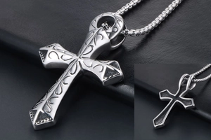Dettaglio macro del ciondolo a croce punk argento con motivi vintage e catena box