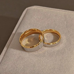 Bagues de couple bicolores en acier inoxydable avec texture rainurée sur boîte en velours