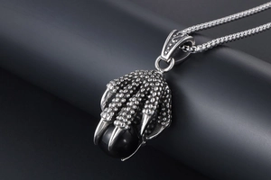 Macro shot of stainless steel dragon claw pendant holding a polished black bead