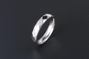 Dettaglio dell'anello in acciaio al titanio argento con motivi geometrici sfaccettati
