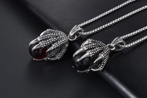 Detailed view of punk dragon claw pendant with red and black beads in silver steel