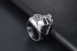 Macro side view of silver skull ring with cross engraving on dark leather background