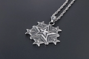 Détail macro du pendentif étoile vintage superposé avec chaîne torsadée