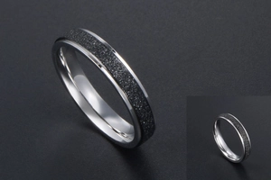 Détail de l'incrustation de sable noir mat et bord en argent poli sur bague métal
