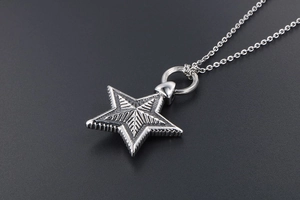 Macro shot of vintage star pendant showing intricate radial lines and industrial metal texture