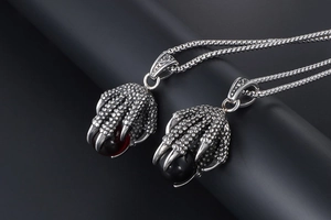 Detail of vintage dragon claw necklace showing scale texture and red/black orb pendants