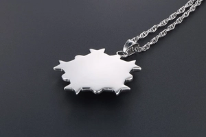 Détail du pendentif étoile en acier inoxydable argenté avec chaîne torsadée sur fond sombre