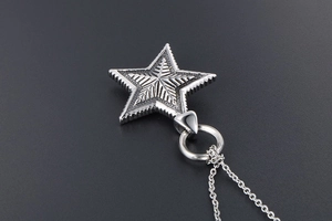 Detailed view of gothic star pendant with radial metal texture and stainless steel chain