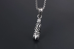 Macro shot of gothic titanium steel pendant with tribal engravings and box chain