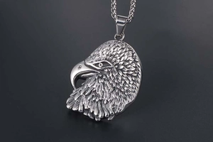 Detailed macro view of an eagle head relief pendant made of polished stainless steel metal