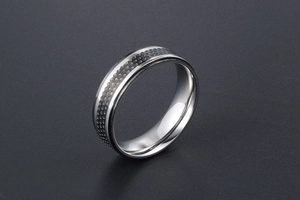 Macro view of stainless steel ring featuring a hammered honeycomb texture and polished edges