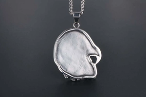 Detailed back view of silver titanium steel skull pendant with textured metal surface