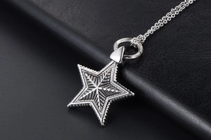 Close-up of vintage stainless steel pentagram star pendant with intricate radial textures