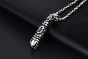 Macro shot of gothic titanium steel pendant with embossed patterns on black leather