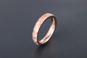Detailed view of rose gold titanium steel ring with unique hammered texture finish