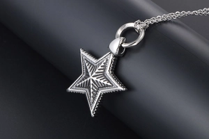 Macro detail of gothic star pendant with radial texture on vintage titanium steel chain