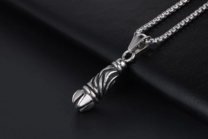 Macro shot of silver gothic titanium steel pendant with spiral texture on black leather