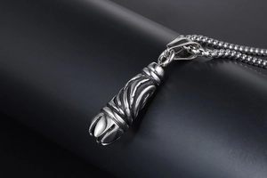 Macro view of gothic titanium steel pendant with spiral patterns and box chain