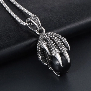 Gothic stainless steel dragon claw necklace with black stone pendant on leather background