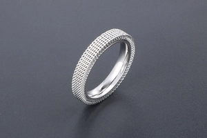 Detailed macro of the silver mesh texture and polished inner band on the titanium steel ring